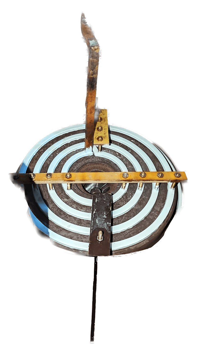 A spiral pancake inductor mounted inside a large copper vessel, with insulated turns and hoses entering from above.