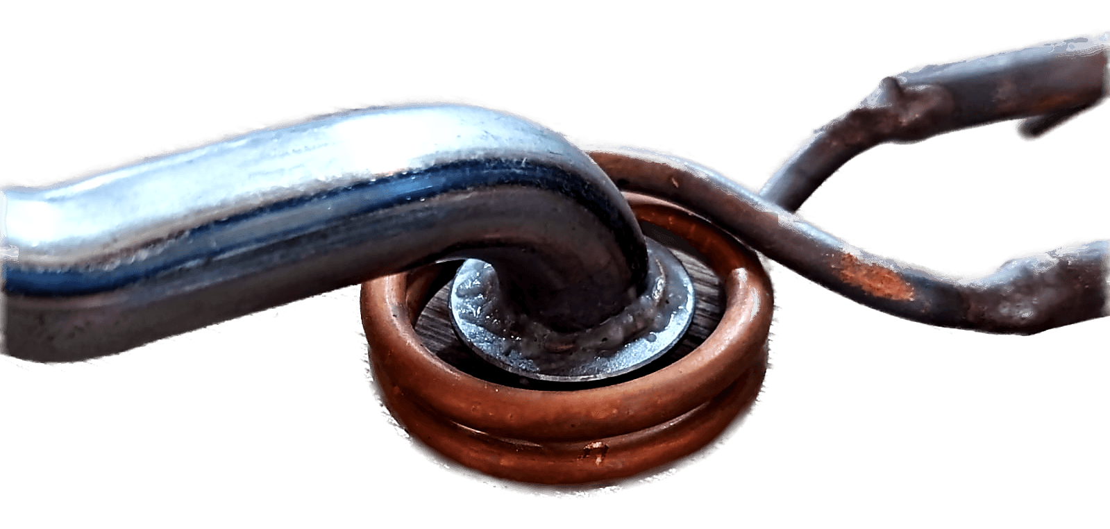 A steel bar resting in a small copper pancake coil on a wooden bench, with the coil connections running off to one side.