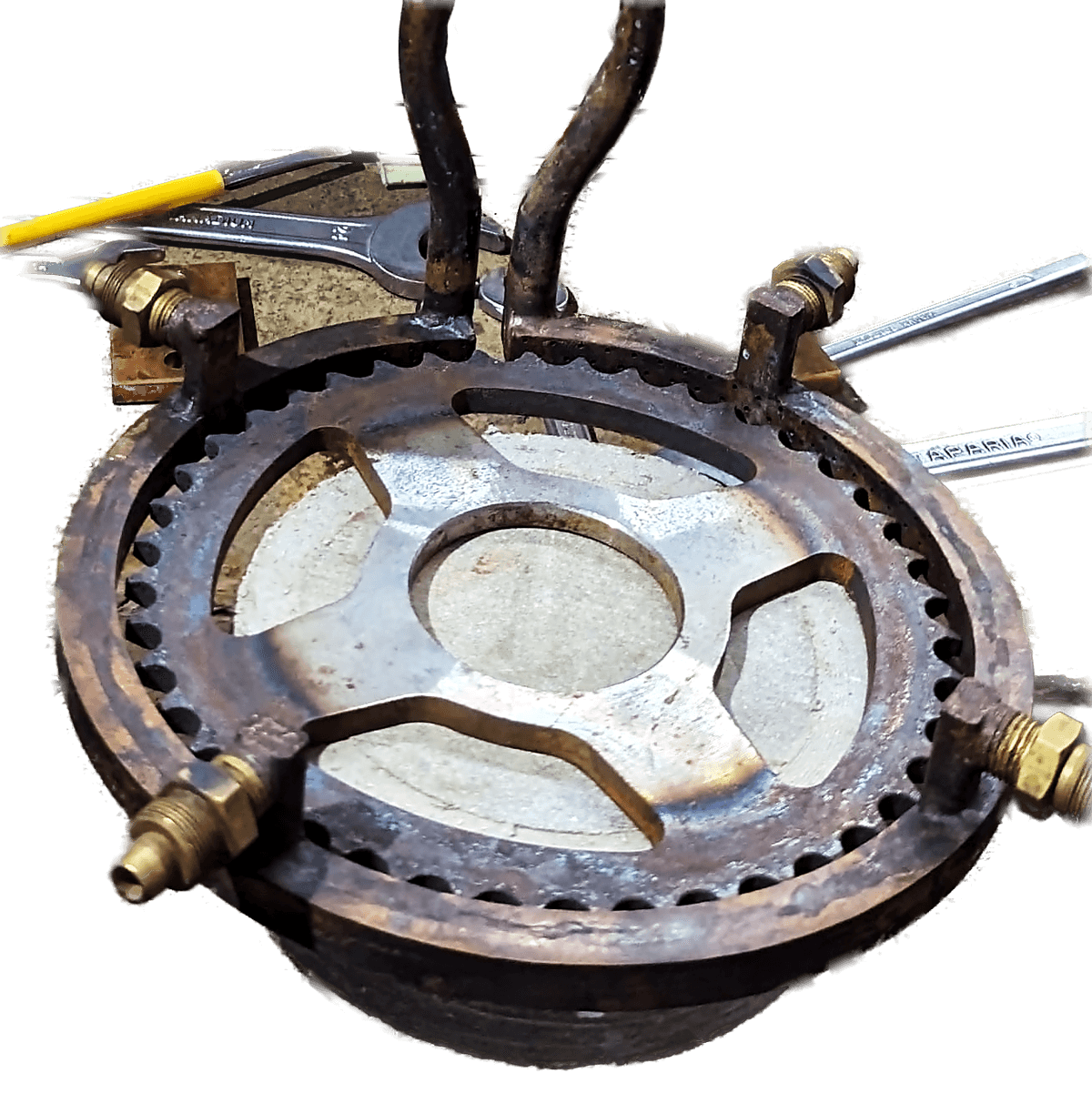 A toothed cast iron ring gear resting on a workbench before treatment, with its inductor connections alongside.